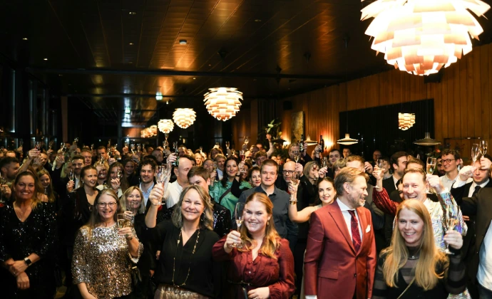 A large group of people waving at the camera.