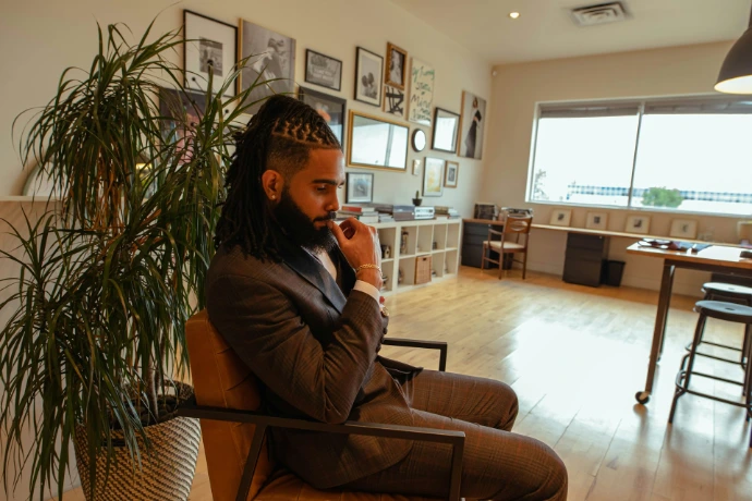 woman in gray long sleeve shirt sitting on brown armchair