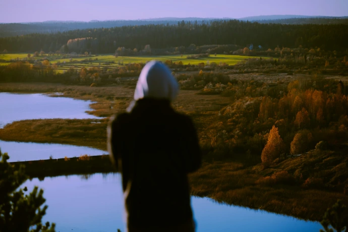 A person standing in front of a body of water